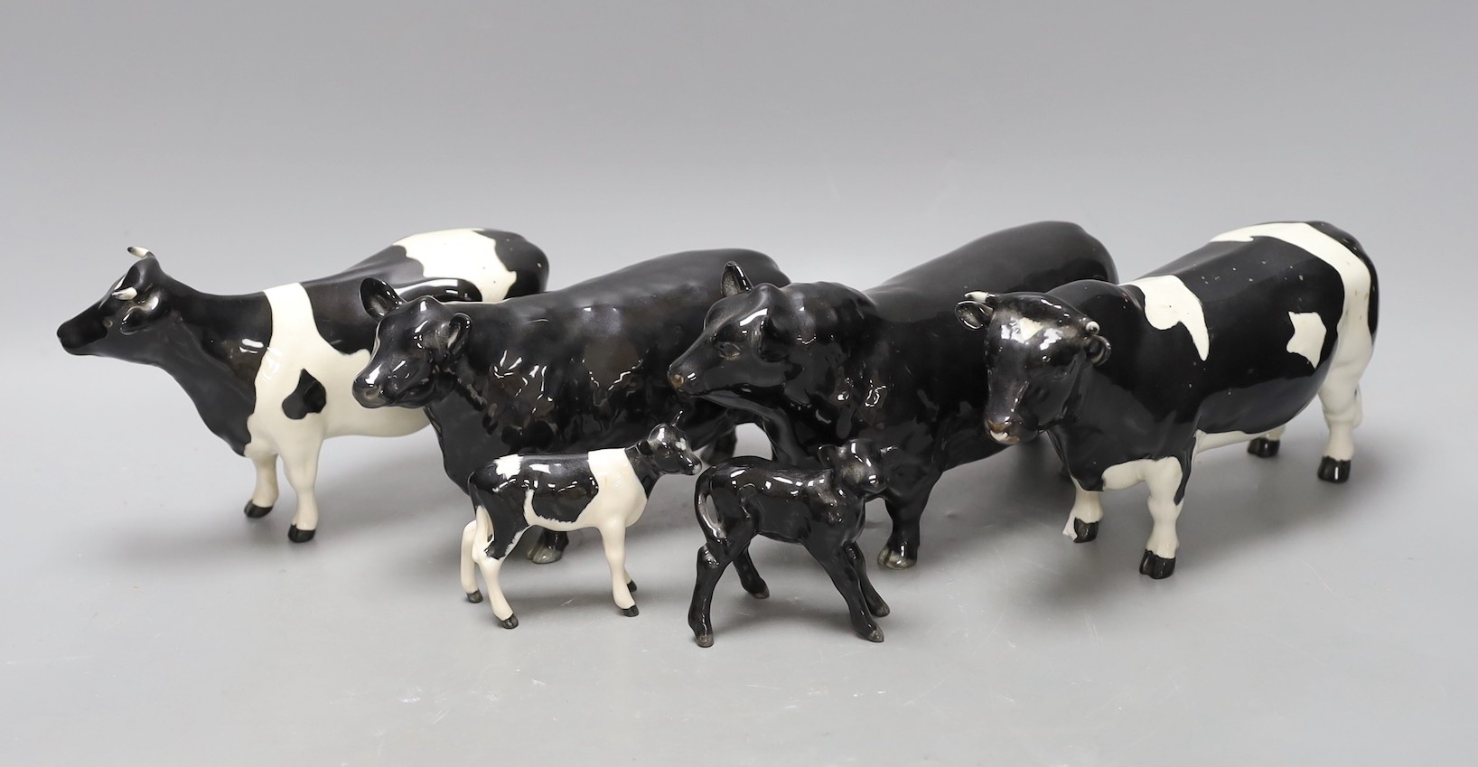 A Beswick Aberdeen Angus bull, cow and calf, together with a Godington Hilt Bar bull, cow and calf